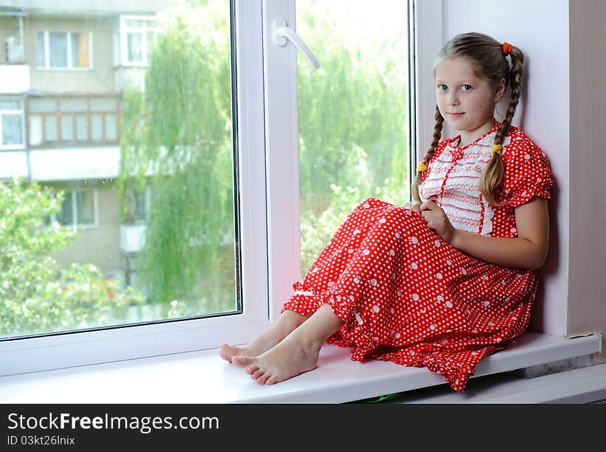 An image of a nicel little girl on the window