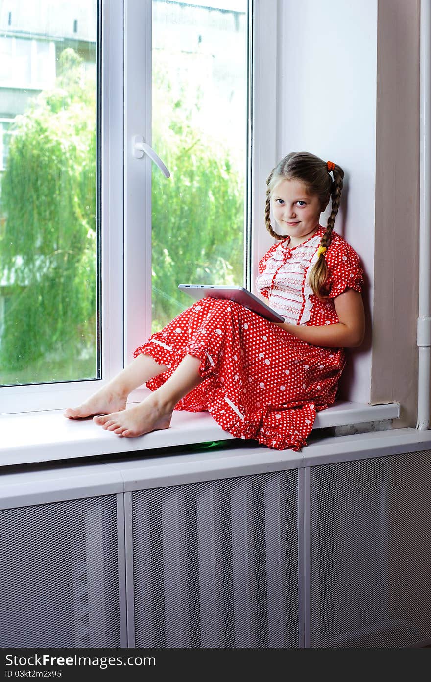 An image of a beautiful little girl on the window. An image of a beautiful little girl on the window