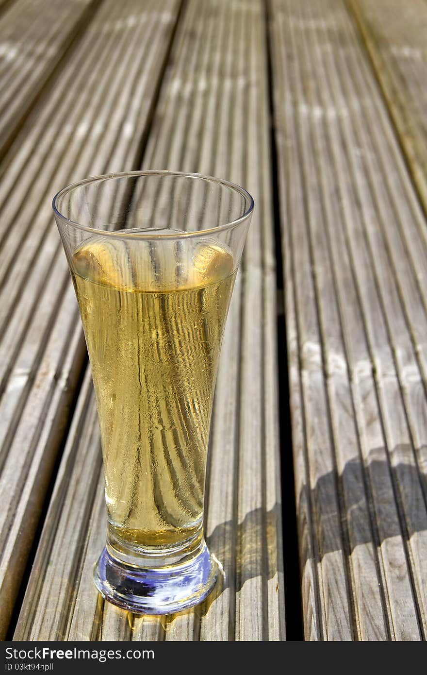 Ice cold beer on wooden decking. Ice cold beer on wooden decking