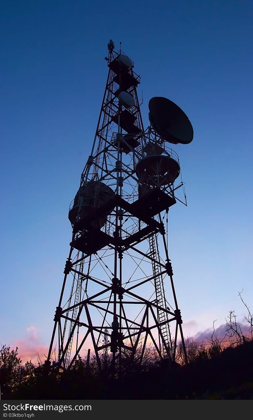 Silhouette of mobile phone communication antenna tower on night sky background