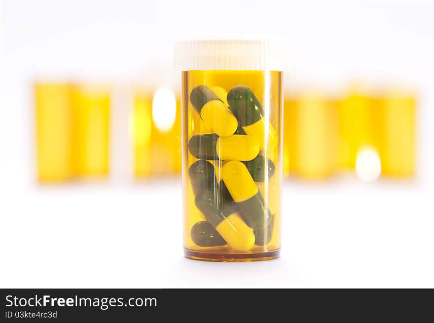 Pill Containers with Green and White capsules inside, all on a bright white background