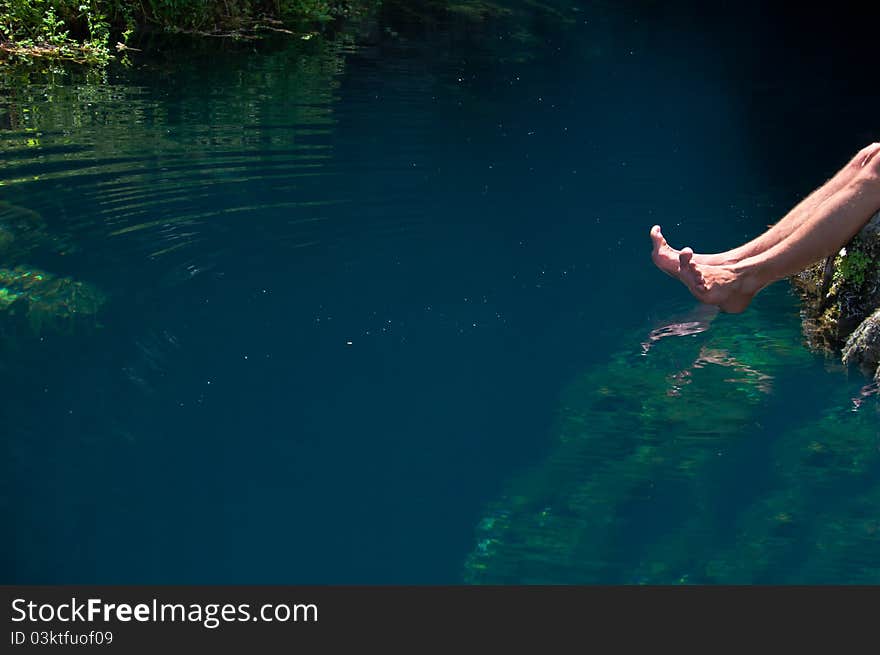 Feet in the water dripping into the river. Feet in the water dripping into the river