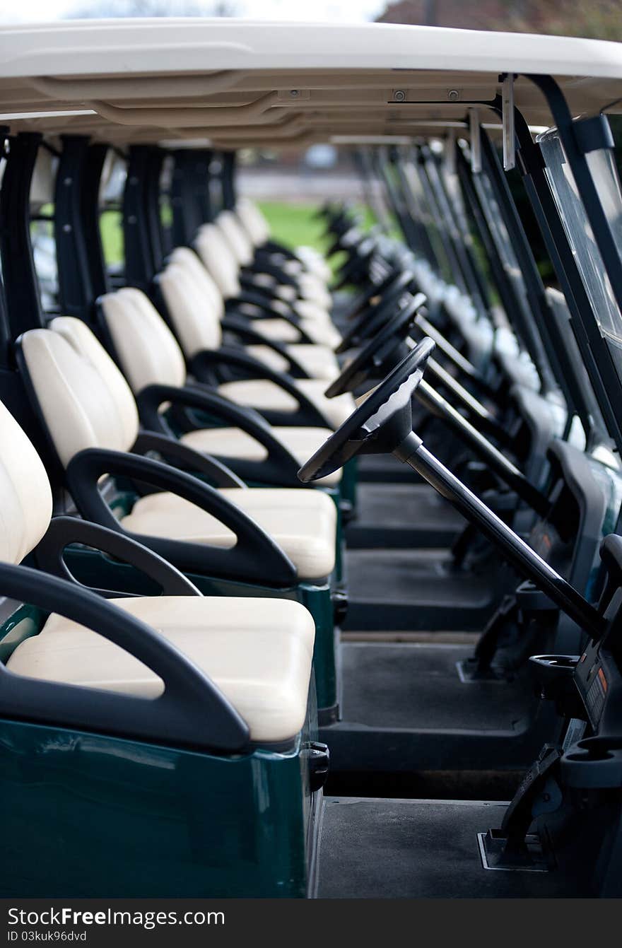 Photograph of a row of golf carts on a course.