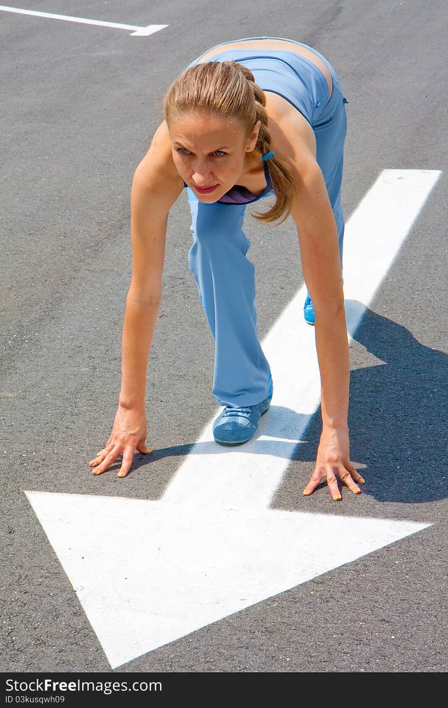 Athletic woman in start position on track