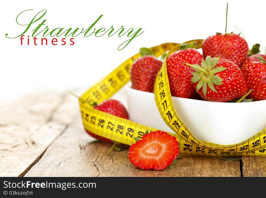 Closeup of a bowl with strawberries and a measure tape with place for your text on the left. Closeup of a bowl with strawberries and a measure tape with place for your text on the left