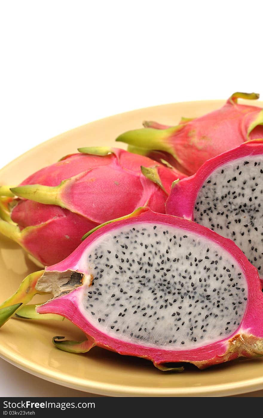 Vertical shot cut dragon fruit on plate with white background and text space. Vertical shot cut dragon fruit on plate with white background and text space