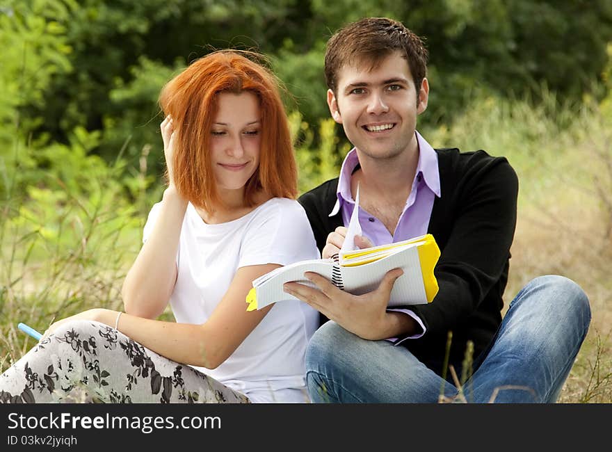 Two students at outdoor doing homework.