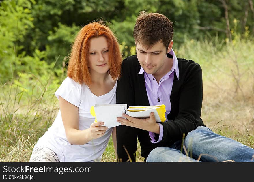 Two students at outdoor doing homework.