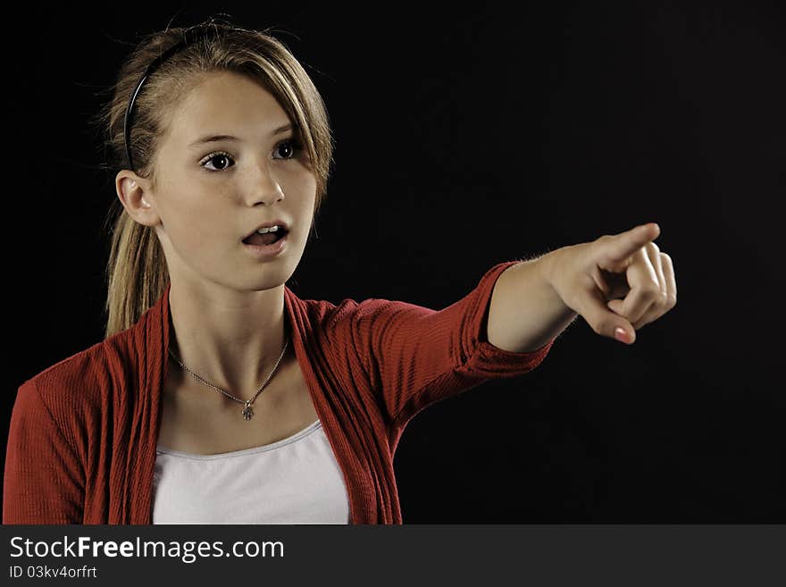 A pretty teenage female girl isolated against a black background. A pretty teenage female girl isolated against a black background.