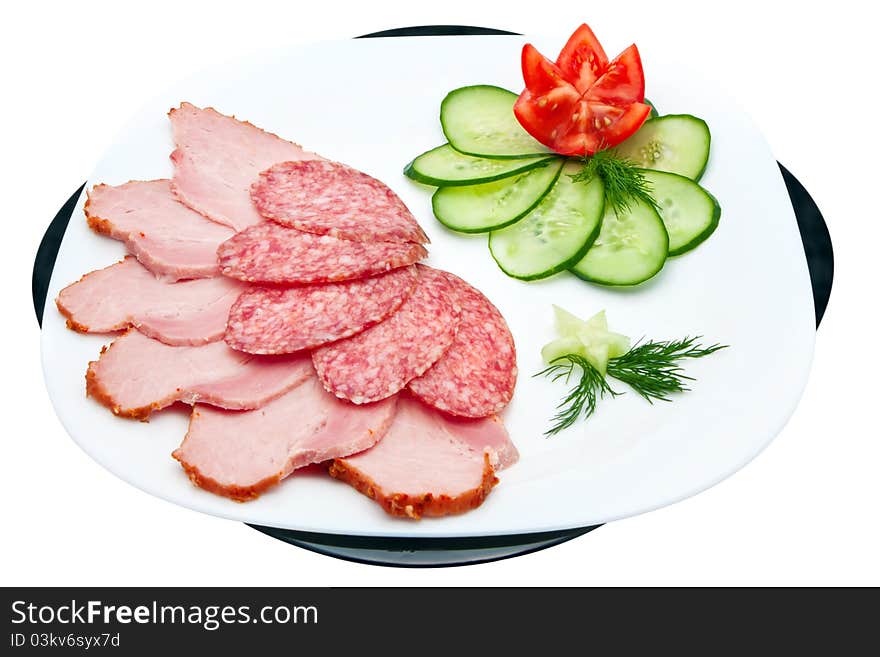 Sliced salami and ham with cucumber and tomato on a plate isolated on a white background. Sliced salami and ham with cucumber and tomato on a plate isolated on a white background