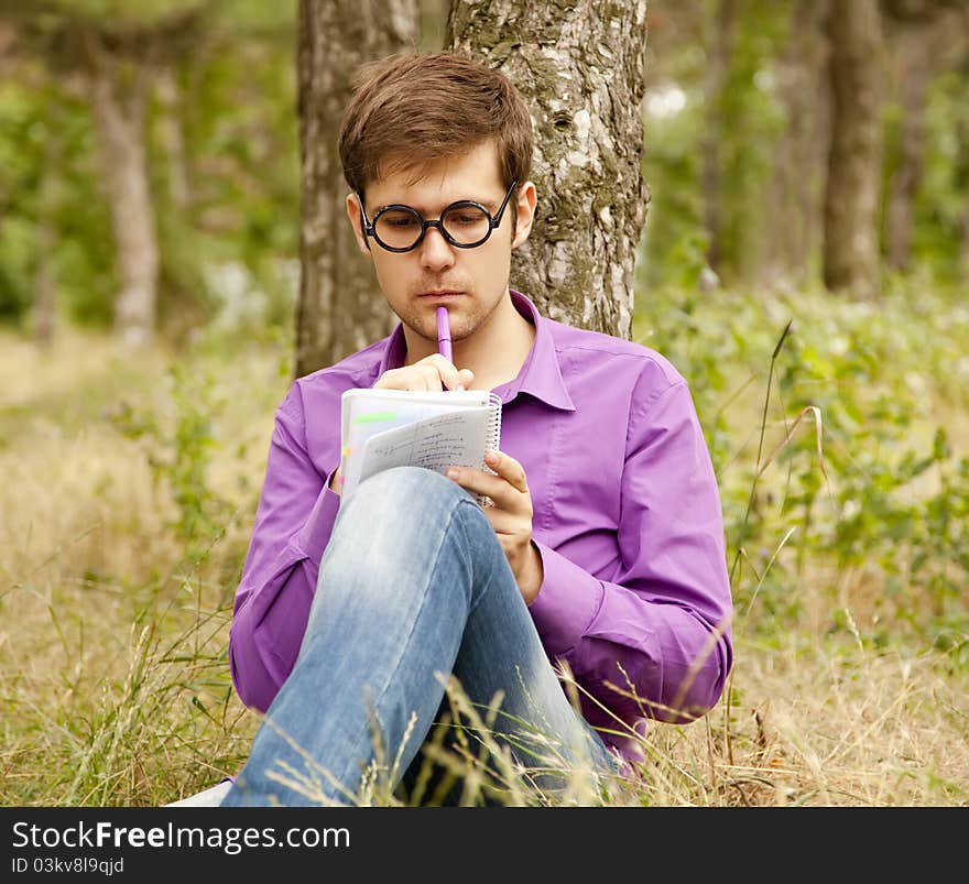 Funny men with glasses doing homework at the park.