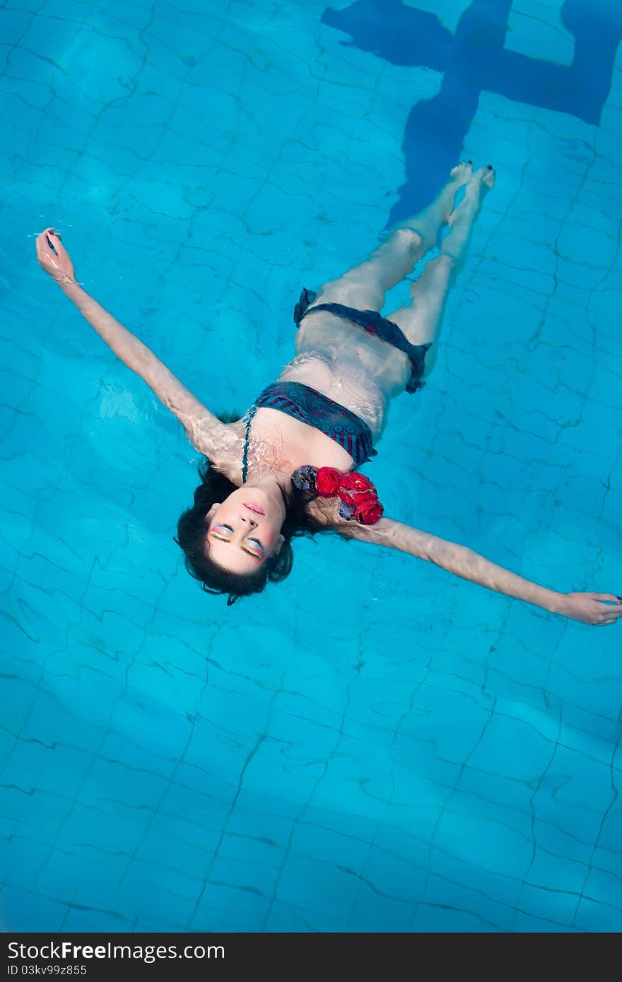 Woman in bikini floating in swimming pool