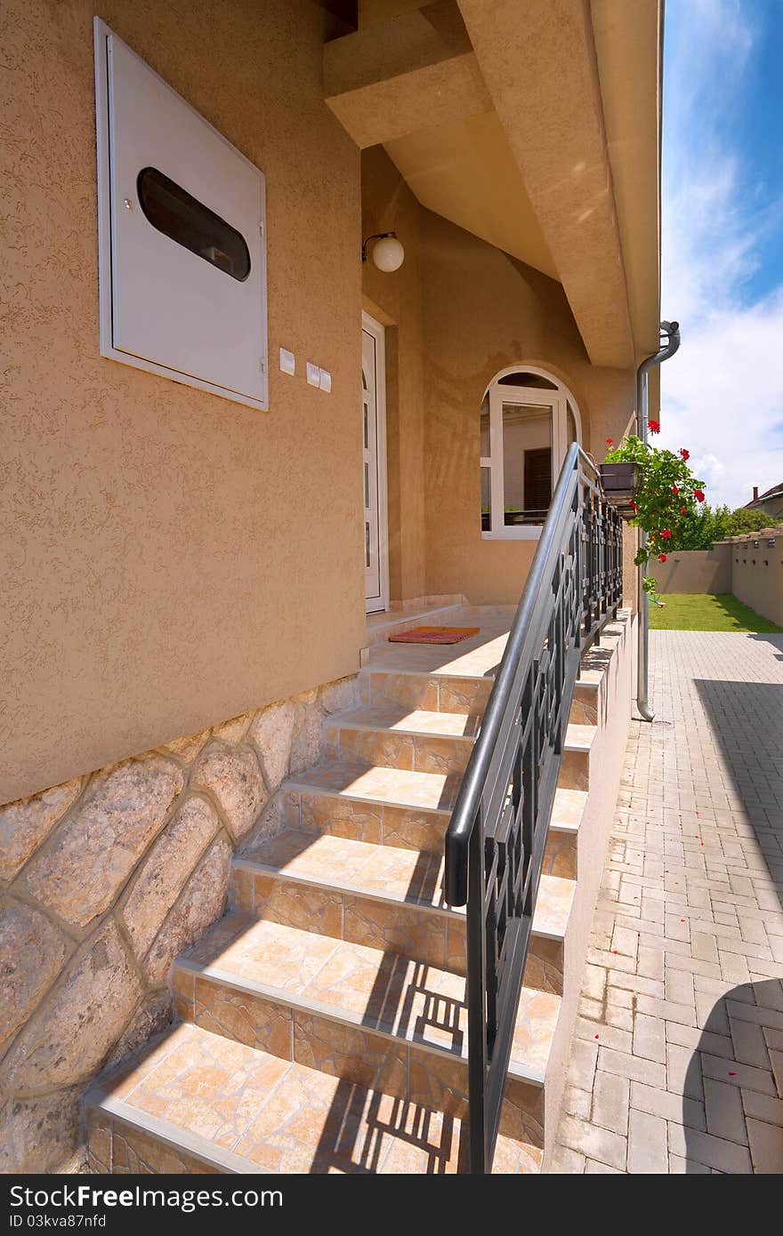 Entrance of a new modern house, brown facade and white door and window. Entrance of a new modern house, brown facade and white door and window.