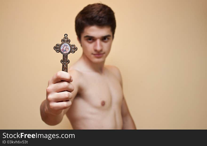 Guy holding cross and looking directly at it