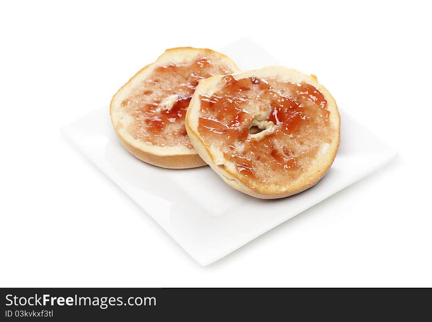 A plain bagel with strawberry jelly against a white background
