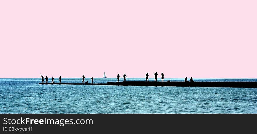 People silhouettes on a breakwater