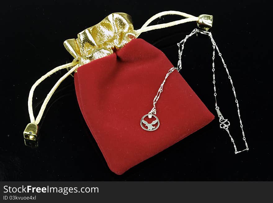 Platinum necklace and a red purse.this purse is used to contain the necklace.