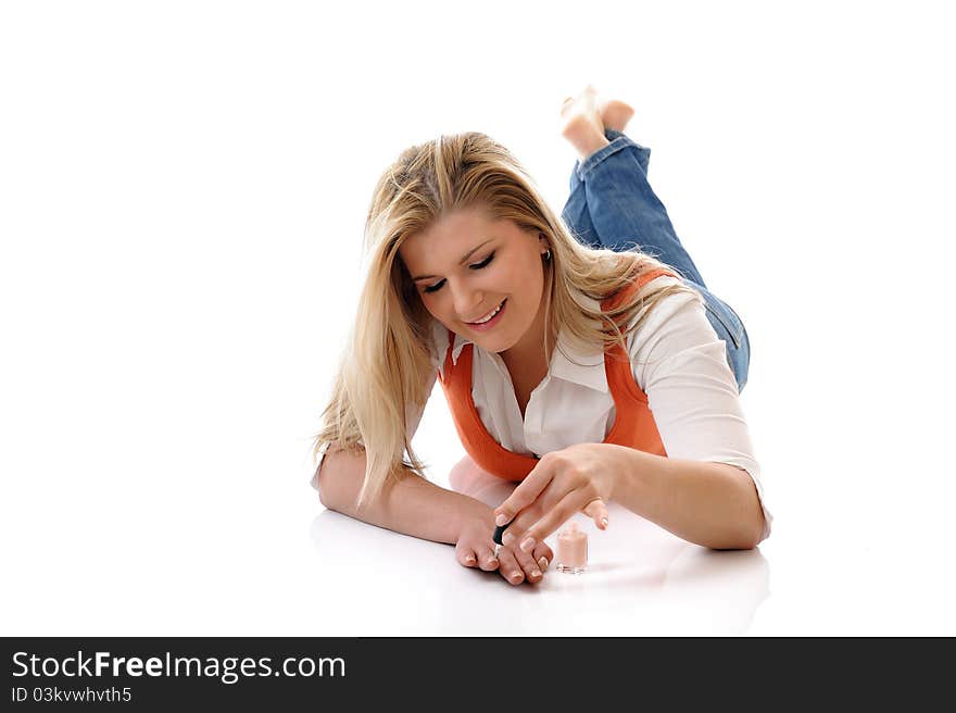 Beautiful girl relaxing lying on the floor and applying nail polish making manicure. isolated on white background. Beautiful girl relaxing lying on the floor and applying nail polish making manicure. isolated on white background