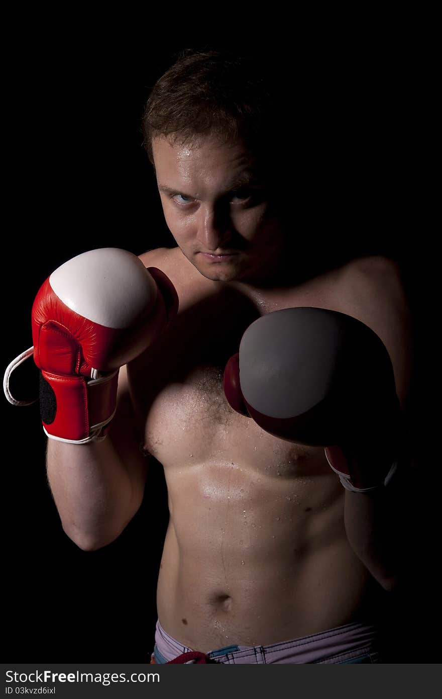 Young Boxer fighter over black background. Young Boxer fighter over black background