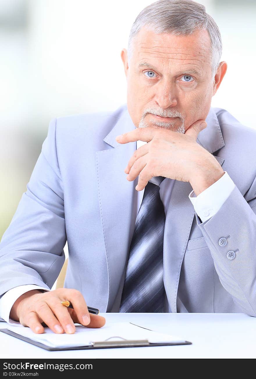 Businessman writing a document in his office. Businessman writing a document in his office