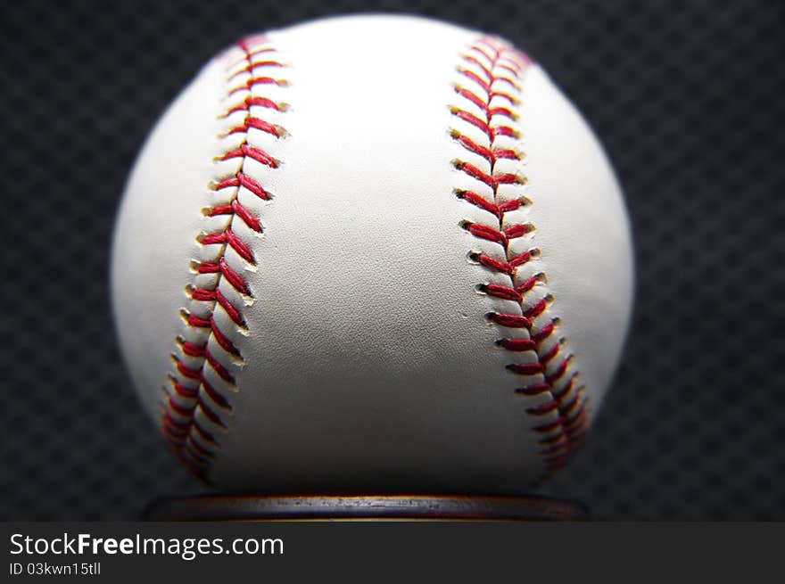 Up close shot of a baseball against a dark background.