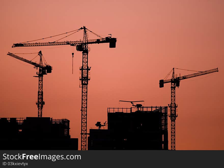 Construction site on sundown, silhouette of the lifting tap. Construction site on sundown, silhouette of the lifting tap