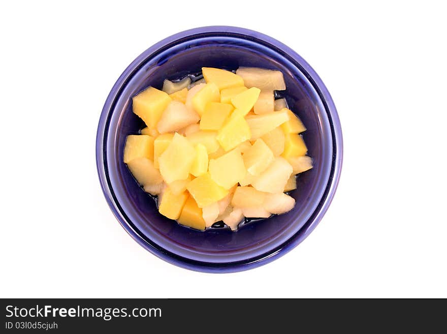 Fruit cocktail in blue bowl isolated over white background