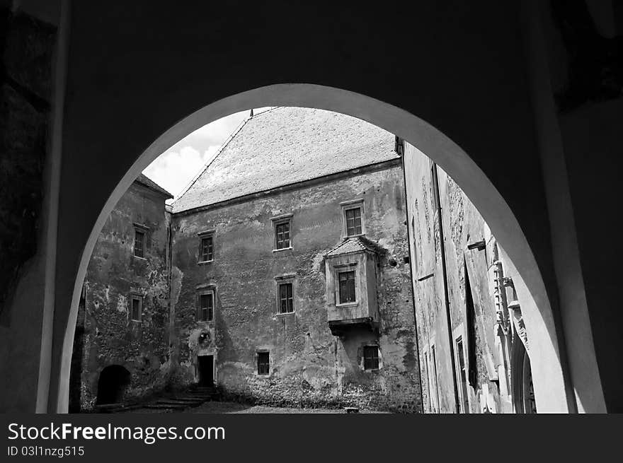 View through an arch towards a stone castle courty