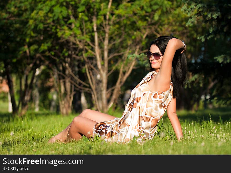 Beautiful brunette sitting on the grass