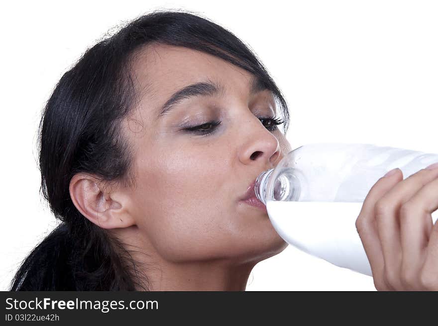 Brunette girl drinking from a bottle isolated