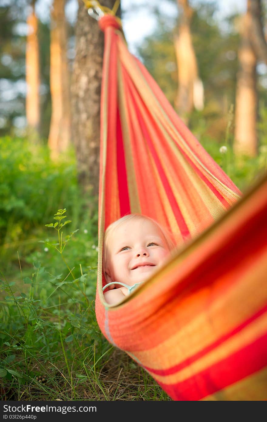 Adorable baby rest in hammock under trees