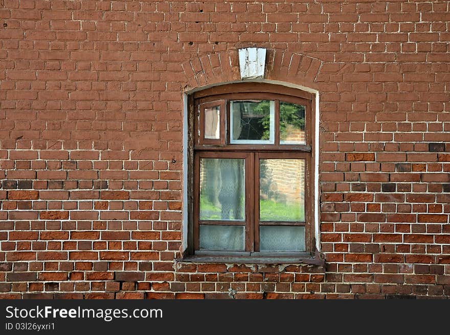 Window in brick wall. The window on the background of the old red brick wall. Window arch in the Art Nouveau style. Vintage window.