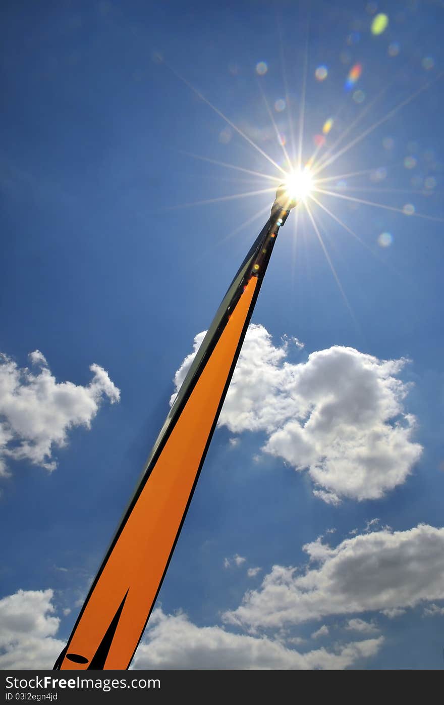 Skiff bows against the sun on a blue sky, like a rocket