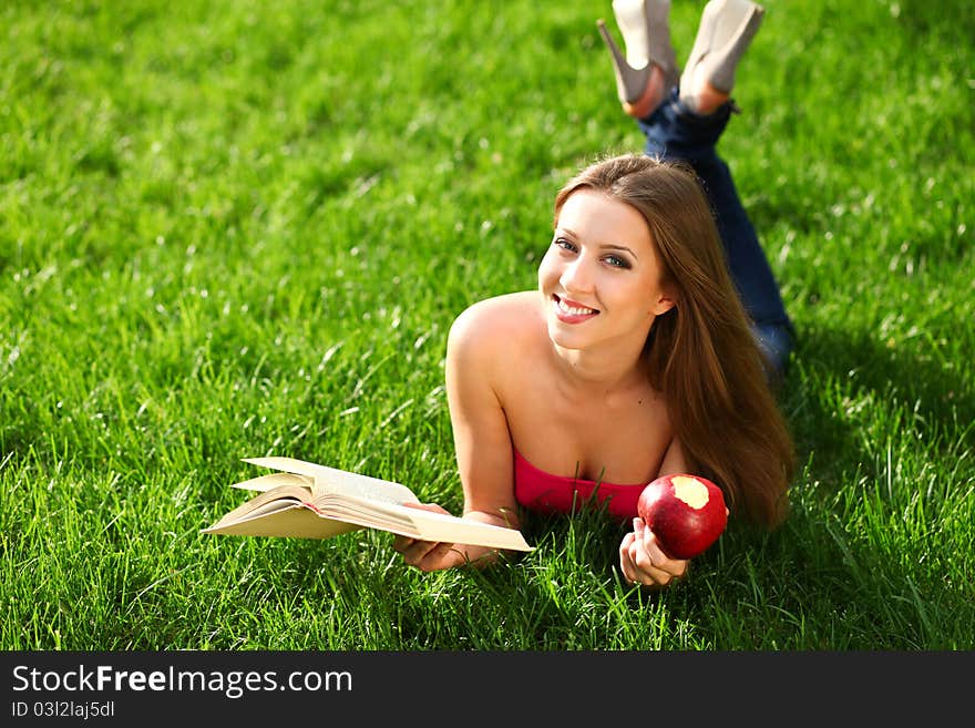 Woman reading book in the park on the grass. Woman reading book in the park on the grass