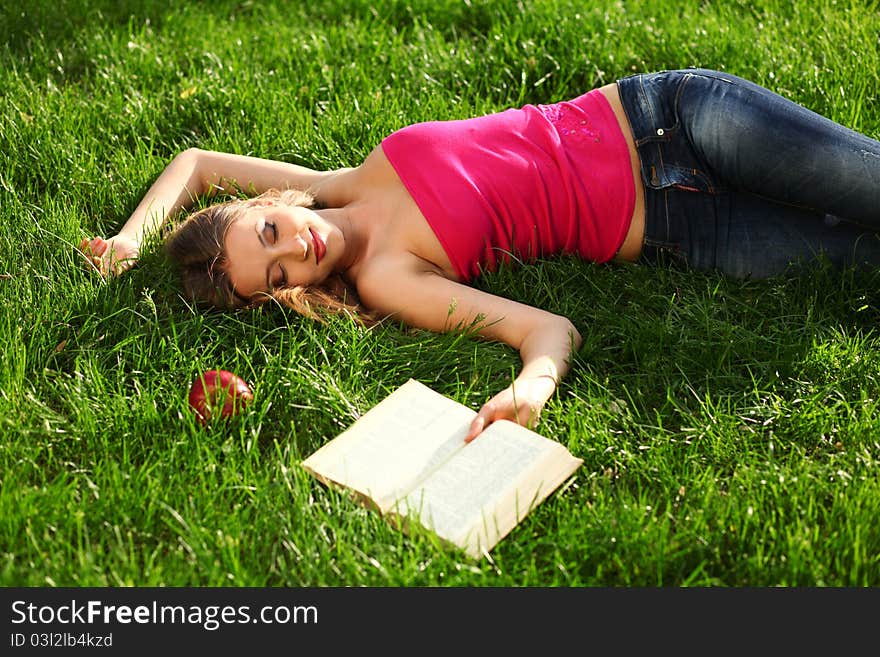 Woman reading book in the park on the grass. Woman reading book in the park on the grass