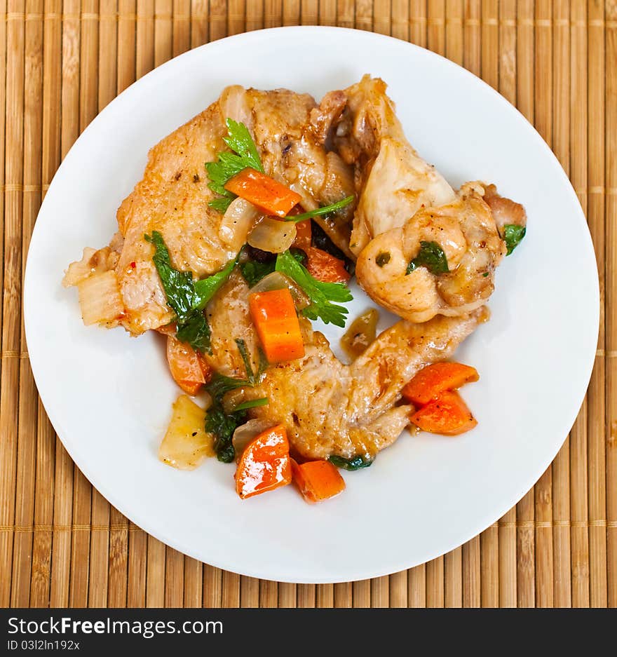 Fried chicken wings with vegetables decorated with parsley