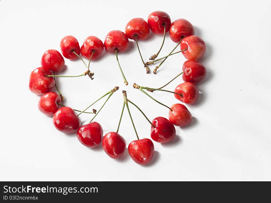 Sweet cherries in the shape of heart isolated on white background. Sweet cherries in the shape of heart isolated on white background