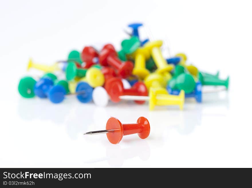 A colorful thumb tack against a white background