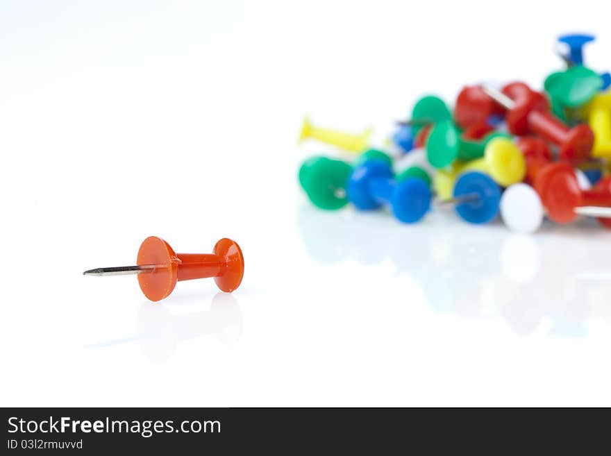 A colorful thumb tack against a white background