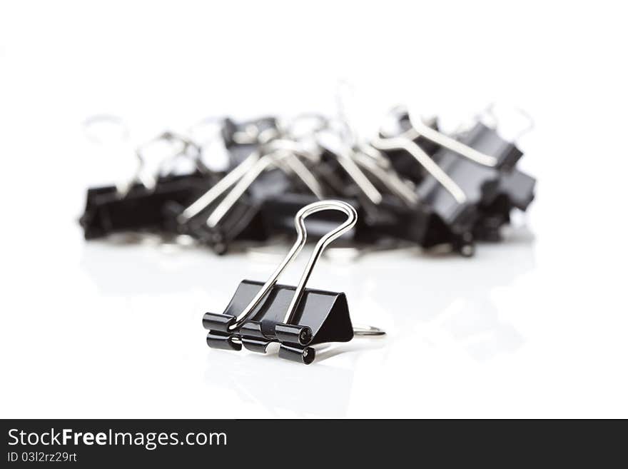 A black binder clip against a white background