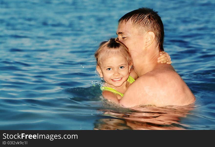 Dad and daughter swimming in the sea