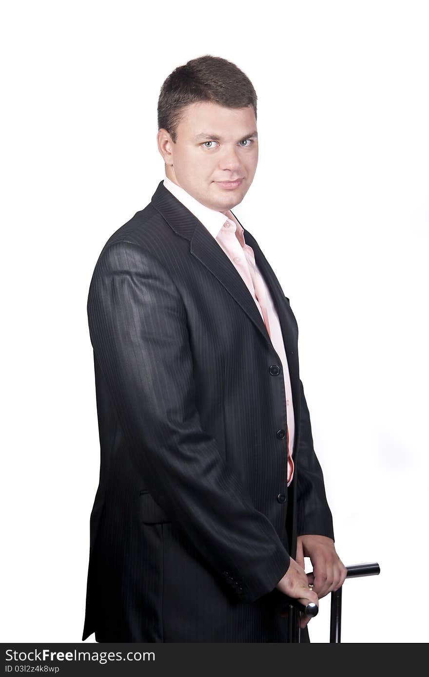 Thoughtful Guy In A Suit Standing Beside The Chair