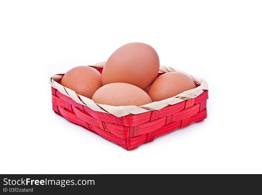 Eggs in a wicker red basket on white background