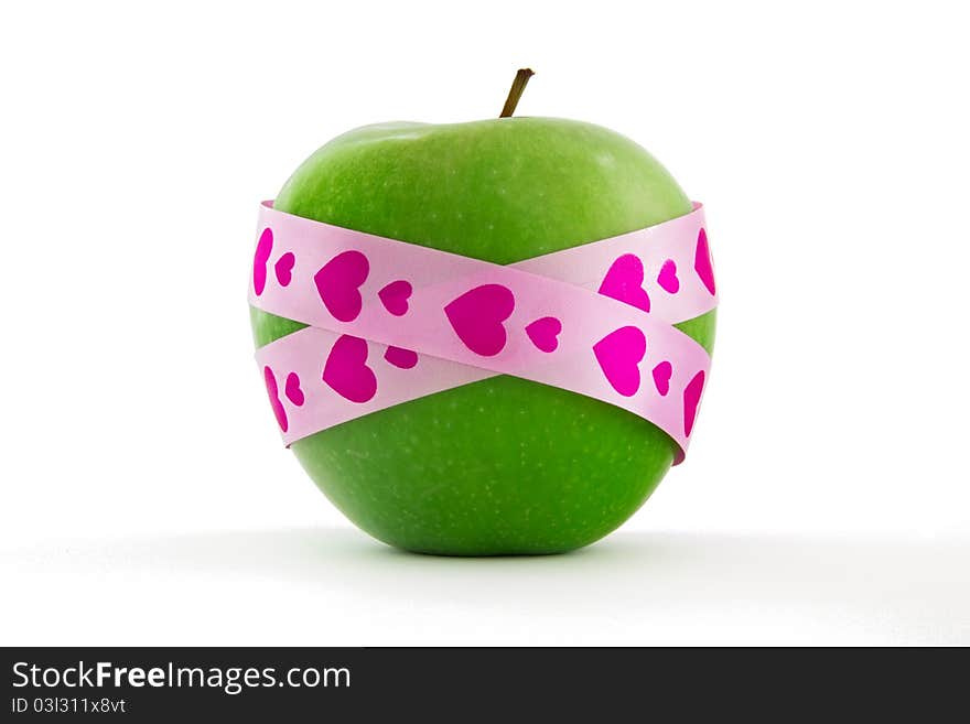 Green apple with pink gift ribbon