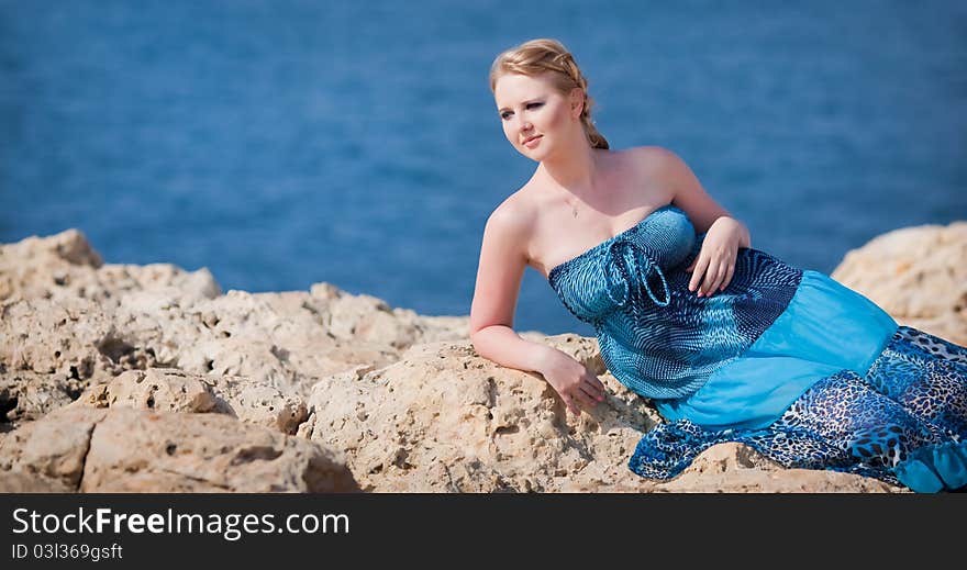 Pretty woman on the rocky mountain near the sea