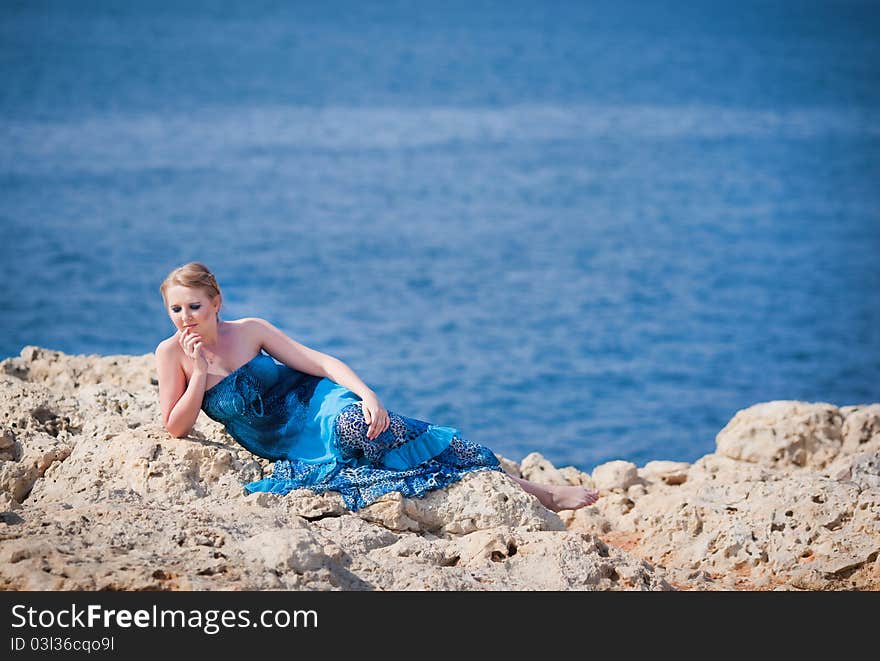 Pretty woman on the rocky mountain near the sea