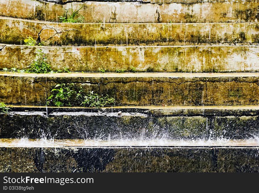 Rain punding down on old and cracked concrete steps