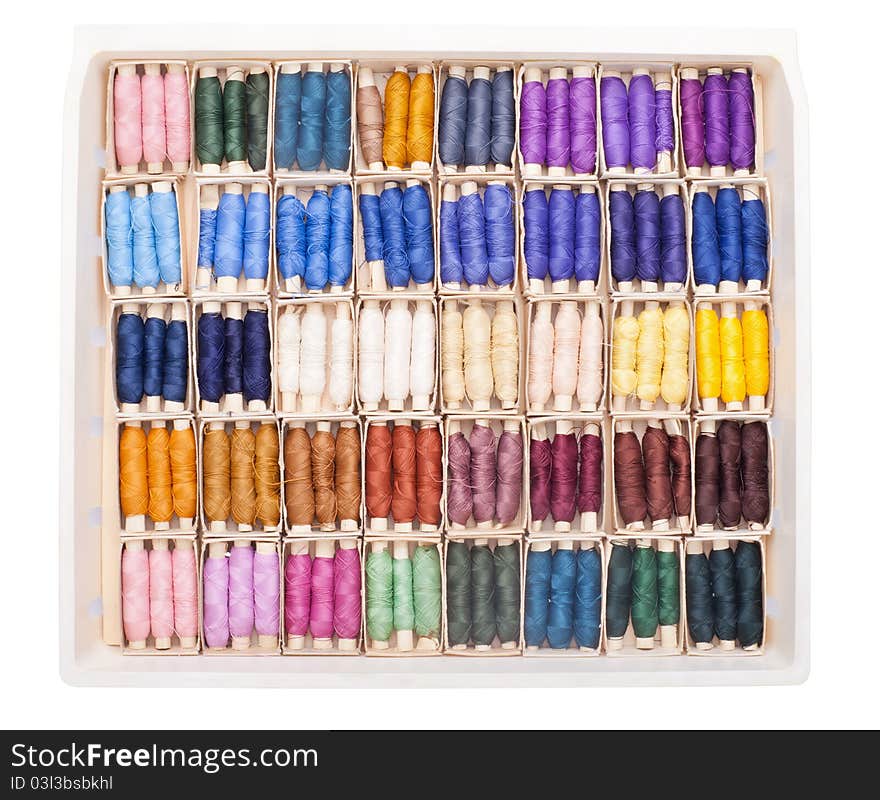 Sewing kit with colored spools of threads isolated