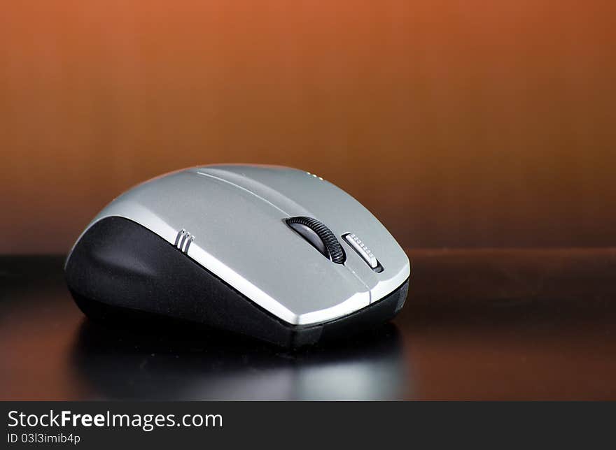 Wireless mouse on brown background