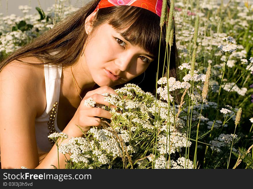 Beautiful girl sitting on meadow